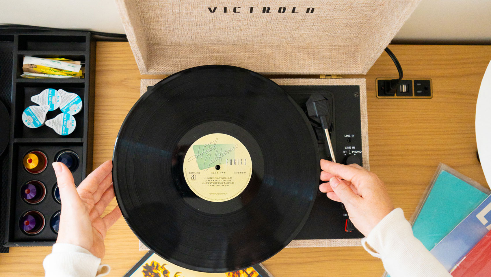 woman puts record onto Victrola player at kimpton alton hotel