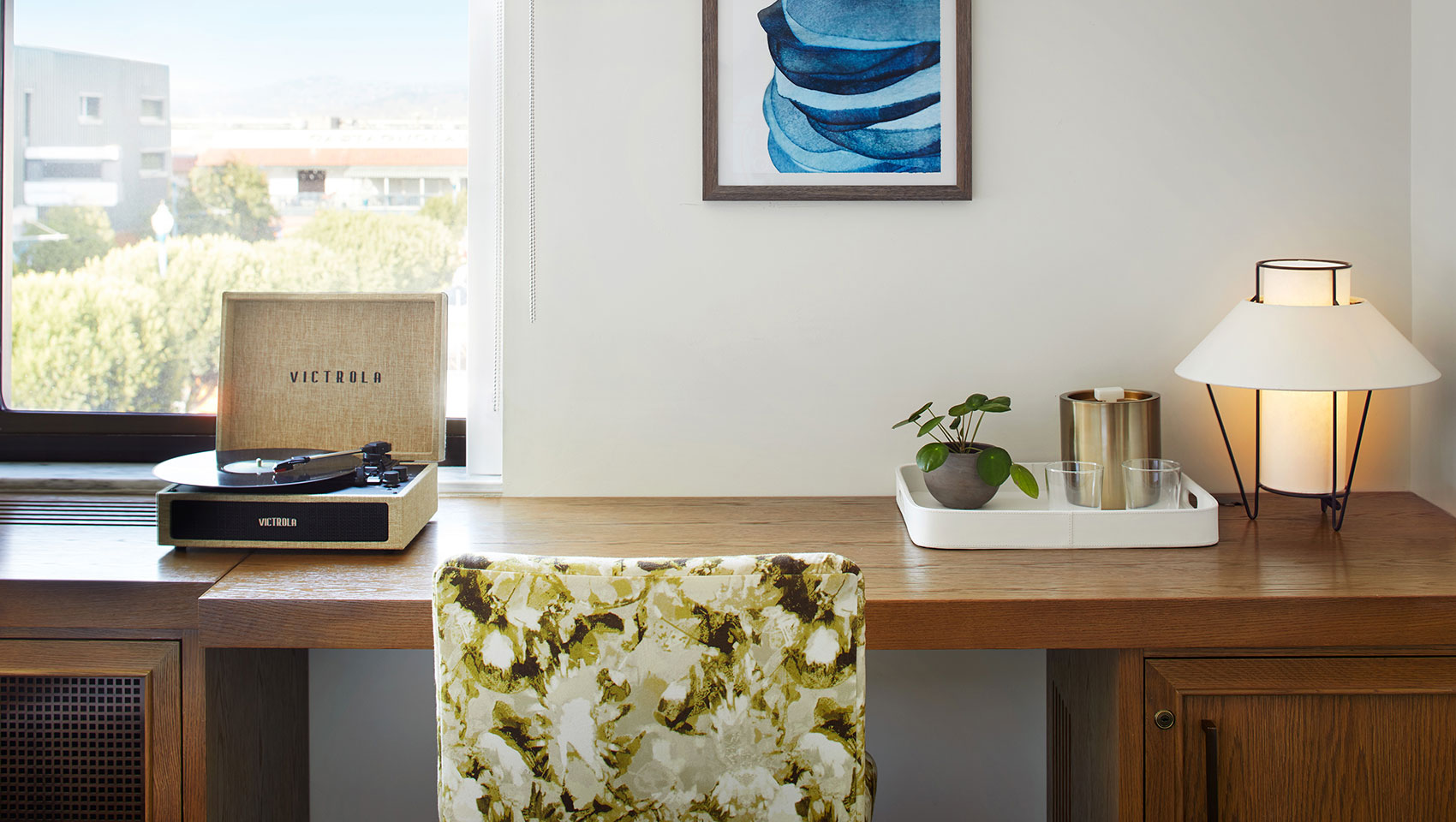desktop in hotel guestroom with  record player and lamp