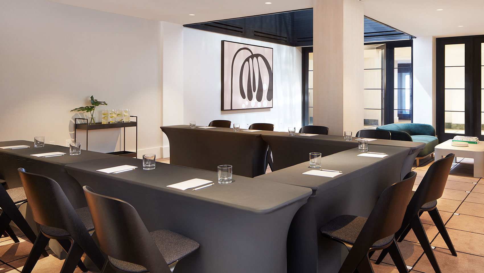 u-shape meeting table sert up with water glasses, pads and pens at kimpton alton hotel